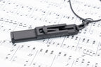 Vocal Trainer lying on printed sheet music with the necklace clip visible.